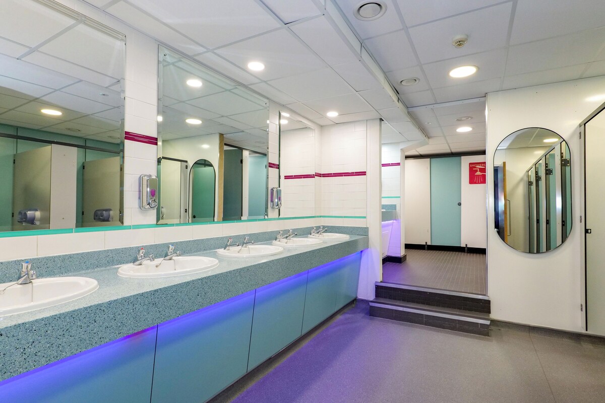 A public restroom with multiple sinks, mirrors, and a tiled floor.