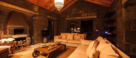 A cozy living room with a fireplace, a sofa, and a coffee table.