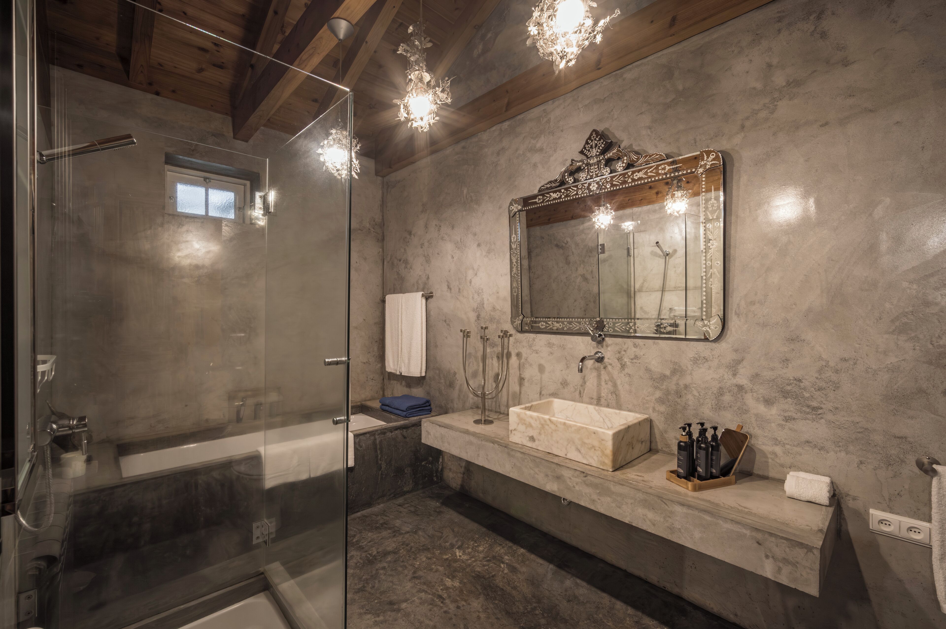 Un baño moderno con cabina de ducha de vidrio, un espejo grande y un lavabo de mármol.