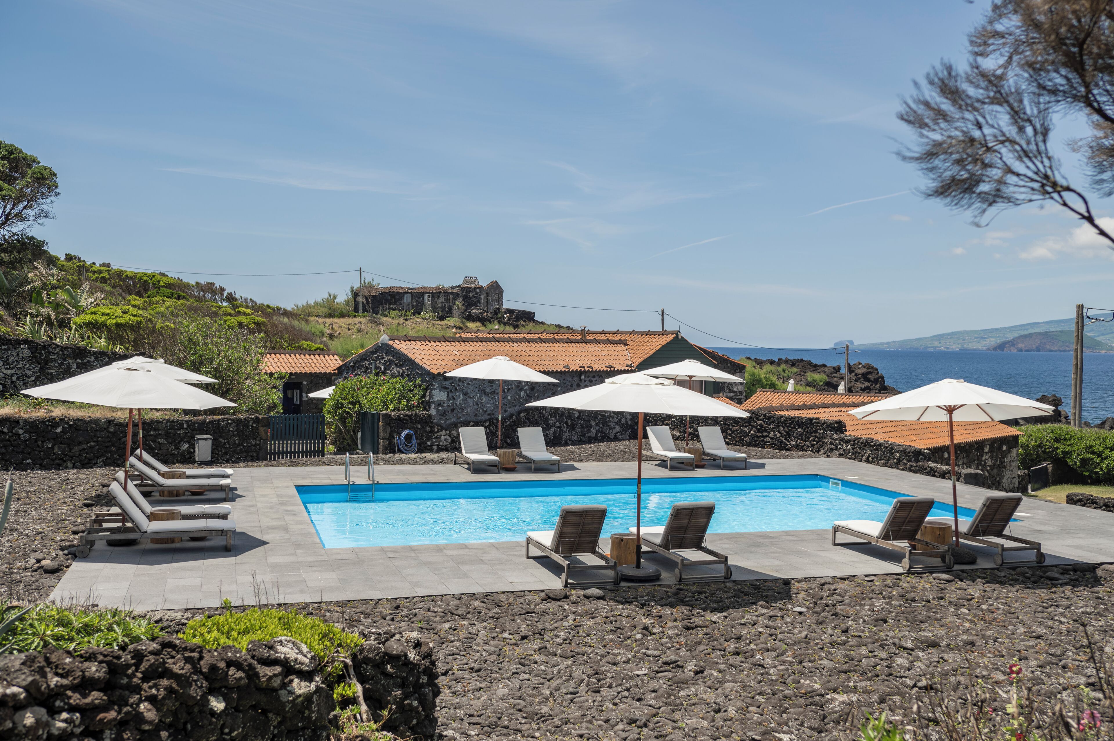 حمّام سباحة خارجي، مظلات على حمّام السباحة، مقاعد للتشمس