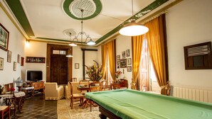 A room with a pool table, a television, and a dining area with chairs and a table. - Quinta de São Caetano (Viseu)