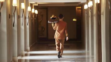 A hotel corridor with a person carrying a tray.