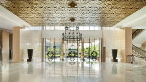 Un hall d’entrée spacieux, doté d’un sol en marbre poli, d’un plafond décoratif et d’un magnifique lustre.