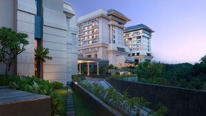 Un hôtel moderne à l’architecture imposante, doté d’un jardin bien entretenu et d’un chemin menant à l’entrée.