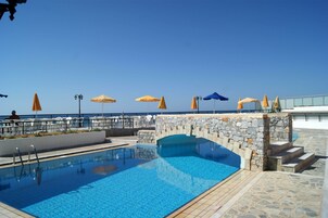 Una piscina al aire libre, sombrillas, tumbonas