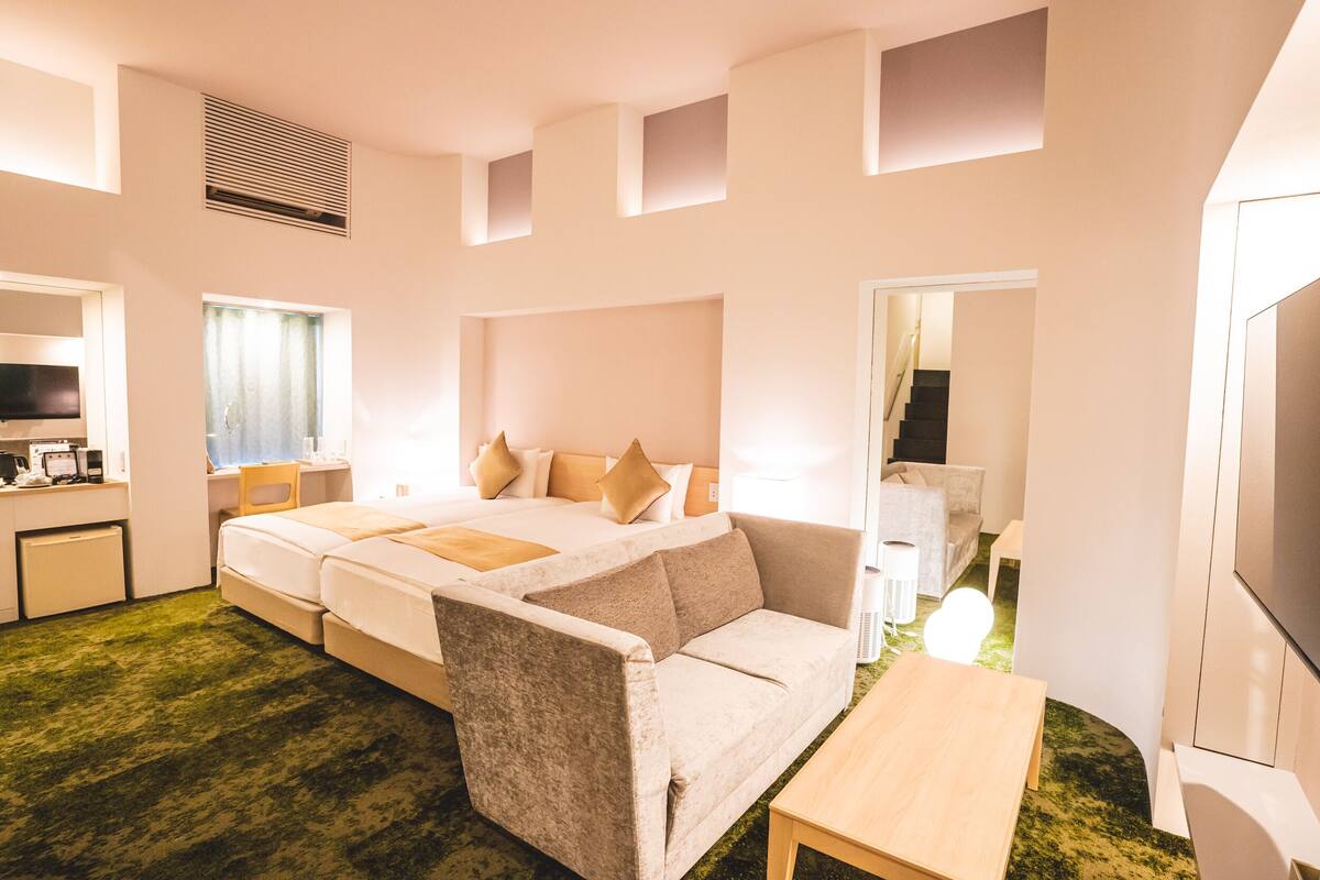 Een hotelkamer met een bed, een bank, een bureau en een televisie.