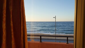 A view of the ocean from a balcony with a railing and a street lamp. - Blue Sky Apartments (Rethymno)