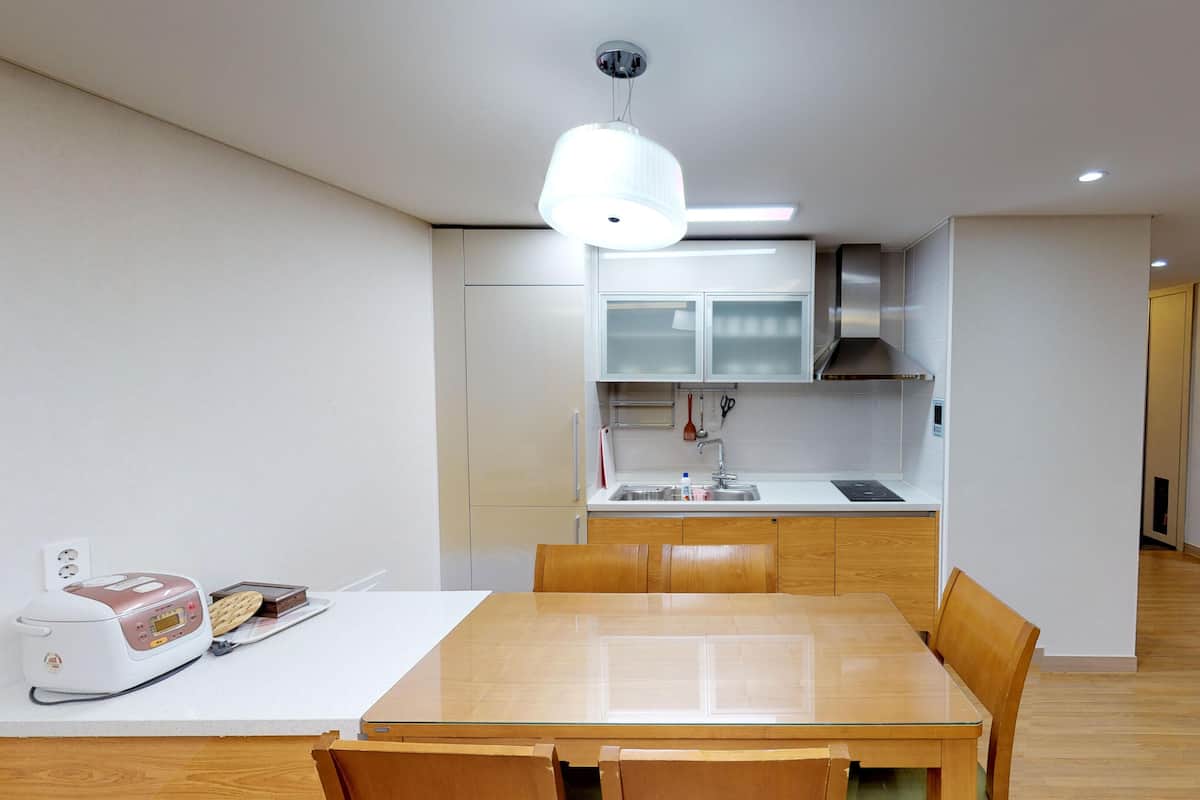 Eine moderne Küche mit Essbereich, Holzmöbeln und einem Einbauofen.