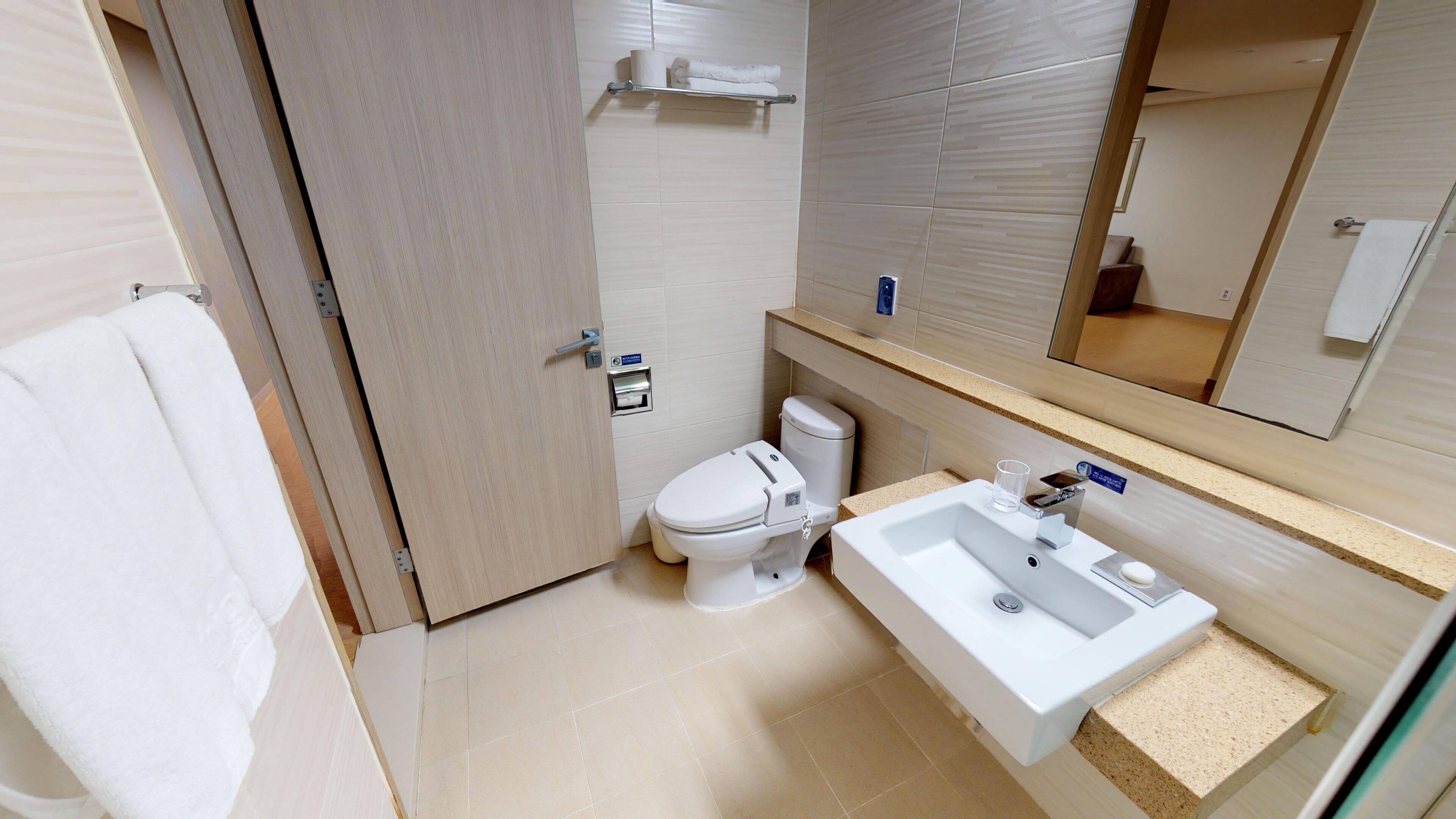 Ein Badezimmer mit Toilette, Waschbecken und Handtuchhalter.