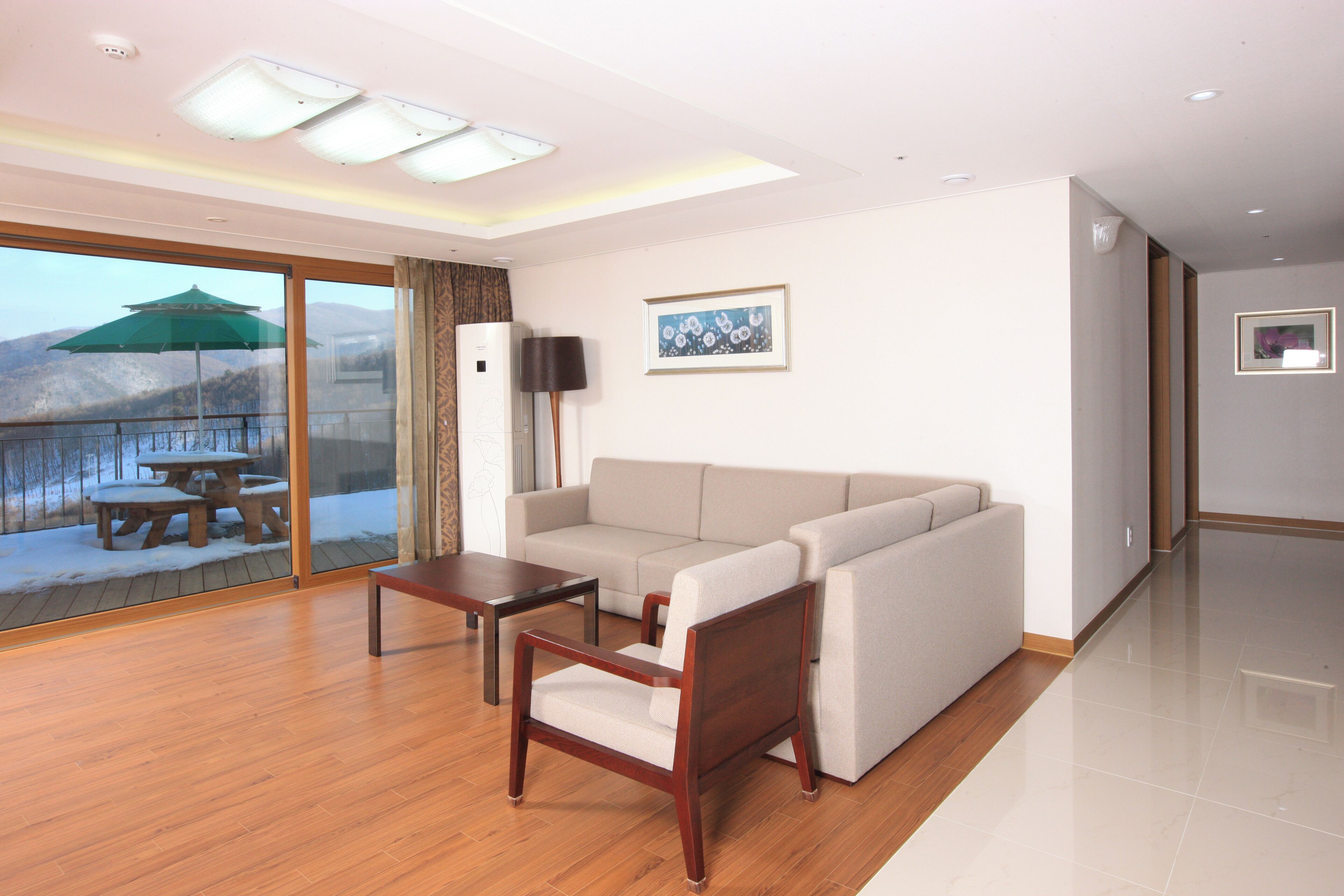 A modern living room with a sofa, a wooden coffee table, and a TV.