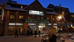 A hotel with a signboard advertising "TOP HOSTEL" and "LOZA" restaurants. - Top Hostel (Zakopane)
