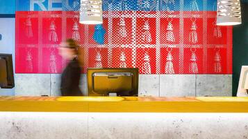 A reception desk with a digital display wall in the background.