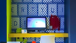 A room with a computer desk, a chair, and a wall with a polka dot pattern. - ibis budget Glasgow (Glasgow)