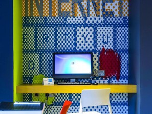Una habitación con un escritorio, una silla y una pared con estampado de lunares.
