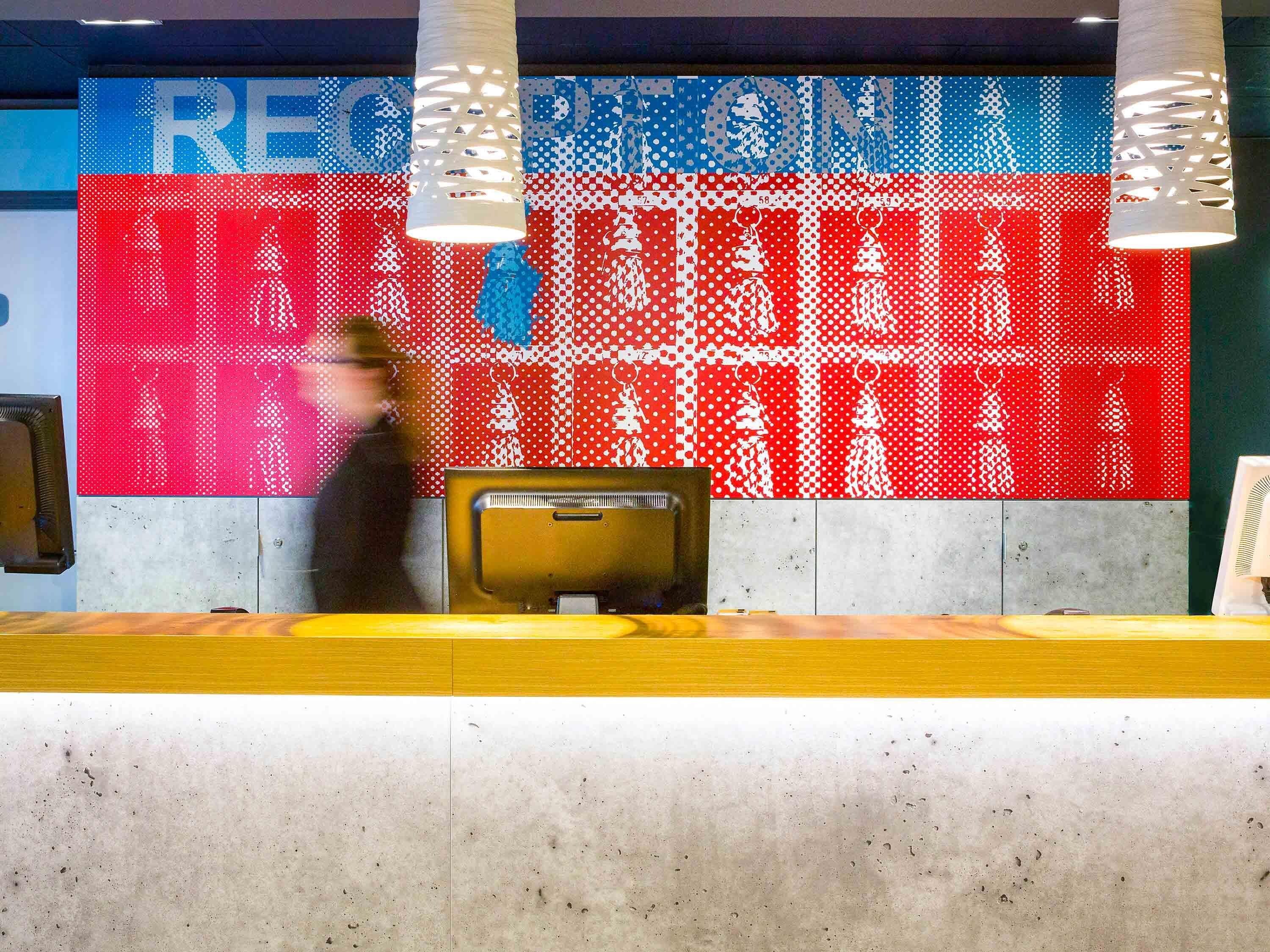 A reception desk with a digital display wall in the background.