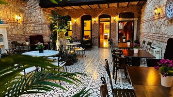Un accogliente ristorante con pareti in pietra, pavimento piastrellato e arredi in legno.