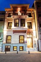 Un edificio a più piani con un'imponente facciata, ampie finestre e una scalinata che conduce all'ingresso principale.