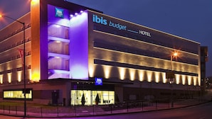 A modern hotel building with a prominent "ibis Budget Hotel" sign.