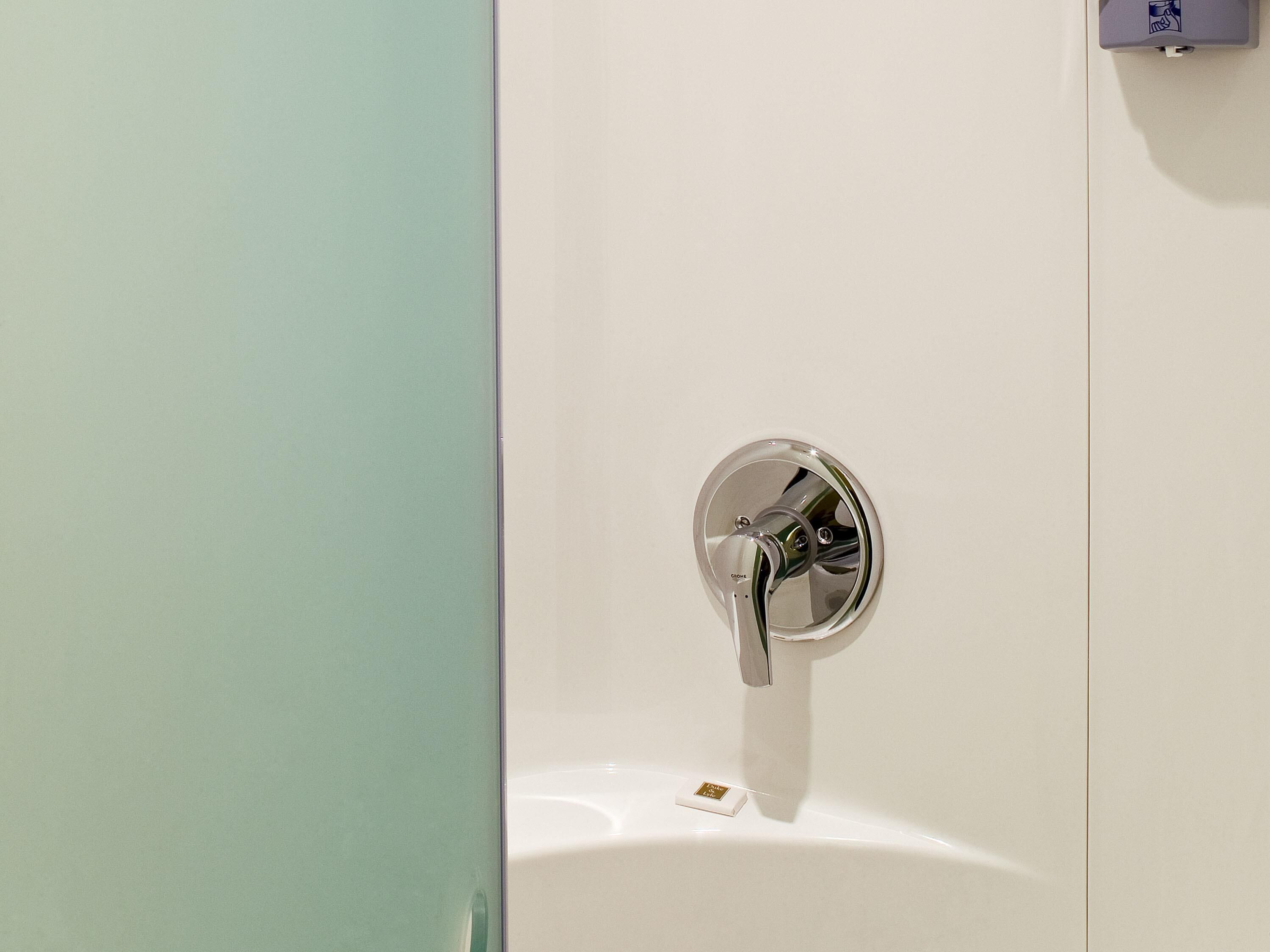 Un baño con un lavamanos blanco y un grifo cromado.