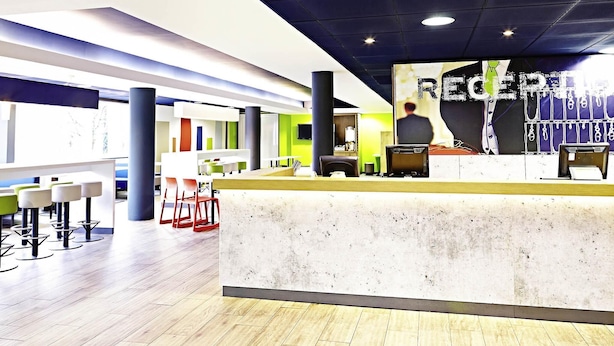 A modern reception area with a counter, seating, and a large poster.