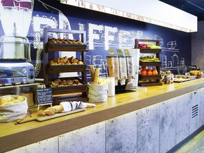 Un buffet per la colazione con diversi cibi, un tostapane e una lavagna con i suggerimenti del menu.