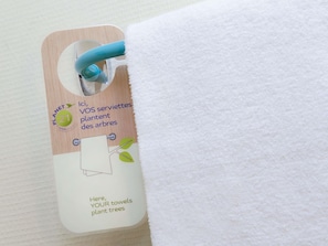 A tag attached to a white towel with a wooden background and a blue handle. - ibis budget Birmingham Centre (Birmingham)