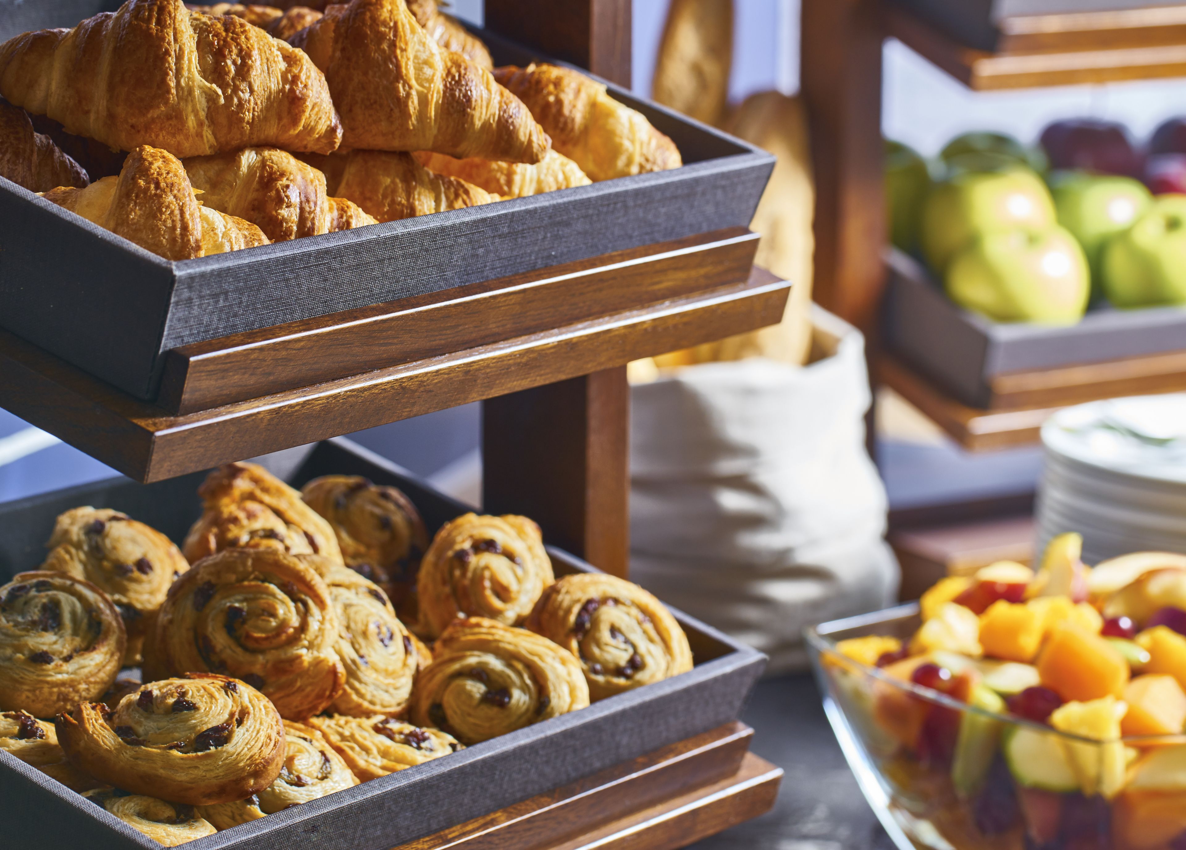 A buffet with pastries and fruits.