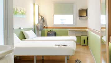 A modern hotel room with two beds, a small desk, a TV, and a suitcase on the floor.