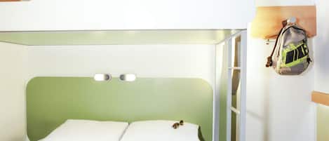 Un letto a castello con un poggiatesta verde, una scala e uno zaino appeso al muro.