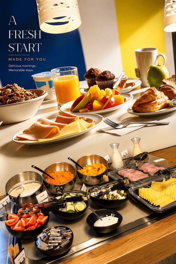 Un bufé de desayuno con diversos alimentos y un cartel que dice 'UN NUEVO COMIENZO PARA TI'.