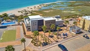 Un hôtel moderne doté d’une piscine, offrant une vue sur la plage et disposant d’un parking.