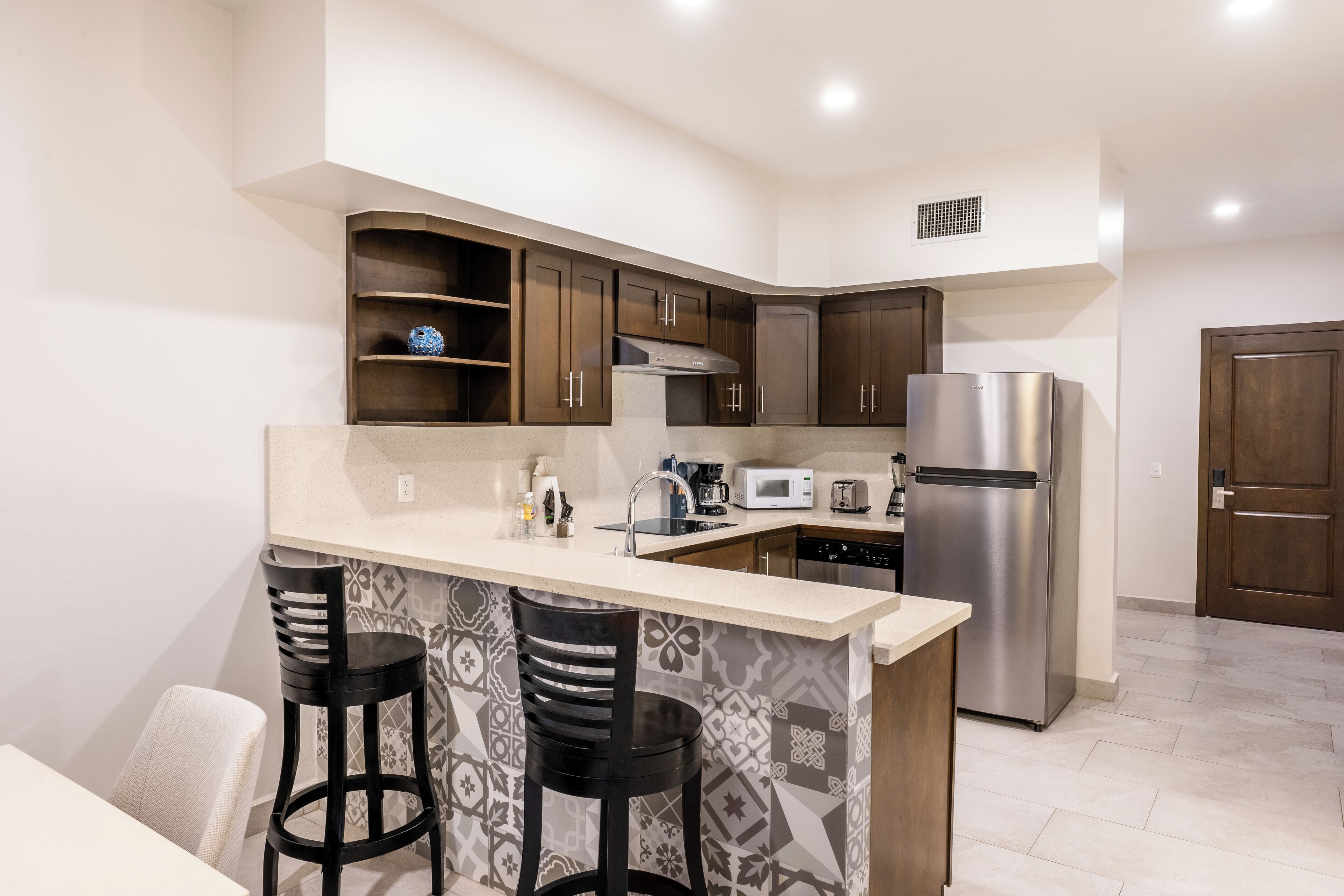 Una cocina moderna con una isla central, electrodomésticos de acero inoxidable y un salpicadero con diseño.