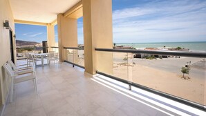 Un balcon avec vue sur la plage et l’océan.