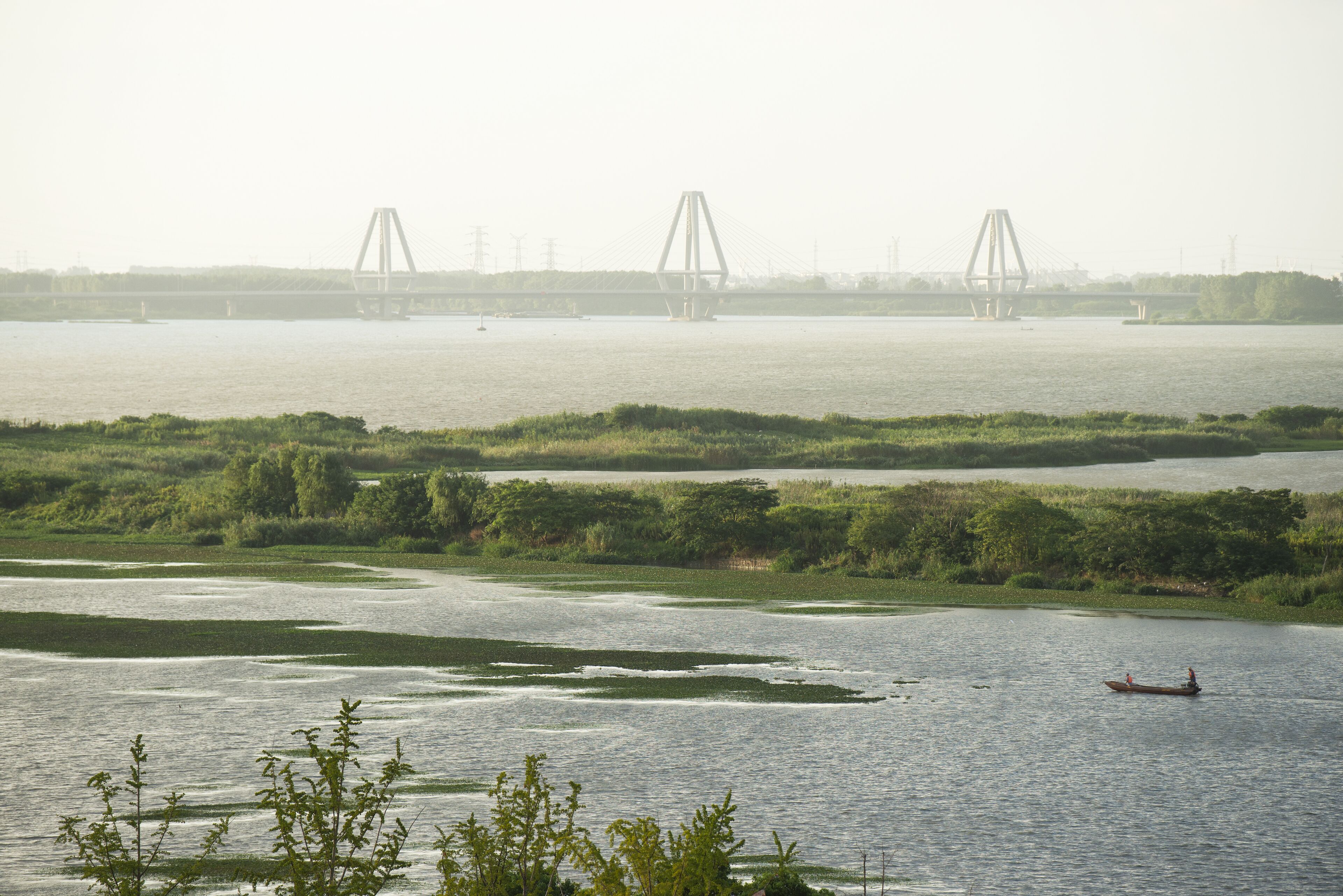 A river with a bridge in the background and a boat in the foreground.