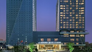 Un hotel con fachada de vidrio moderna, un cartel llamativo y una entrada bien iluminada.