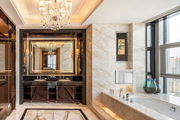 A luxurious bathroom with a large mirror, dual sinks, a bathtub, and a chandelier. - Le Méridien Yixing (Wuxi)