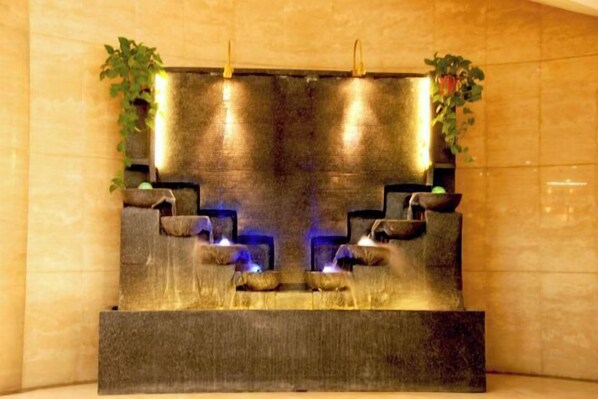 A stone fountain with water features and plants. - Dunhuang International Hotel (Jiuquan)