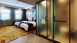 Een moderne hotelkamer met een groot bed, een kledingkast met schuifdeuren en een groot raam met gordijnen.