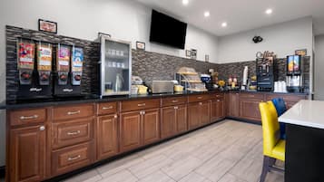 Una cocina moderna con armarios de madera, encimera negra y una zona de café.