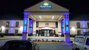 A Days Inn by Wyndham hotel with a covered entrance, multiple windows, and a parking area with cars. - Days Inn by Wyndham Greenville South/Mauldin (Mauldin)