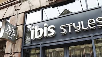 A hotel sign with the name 'ibis Styles' and a smaller sign for 'ibis Styles Hotels'.