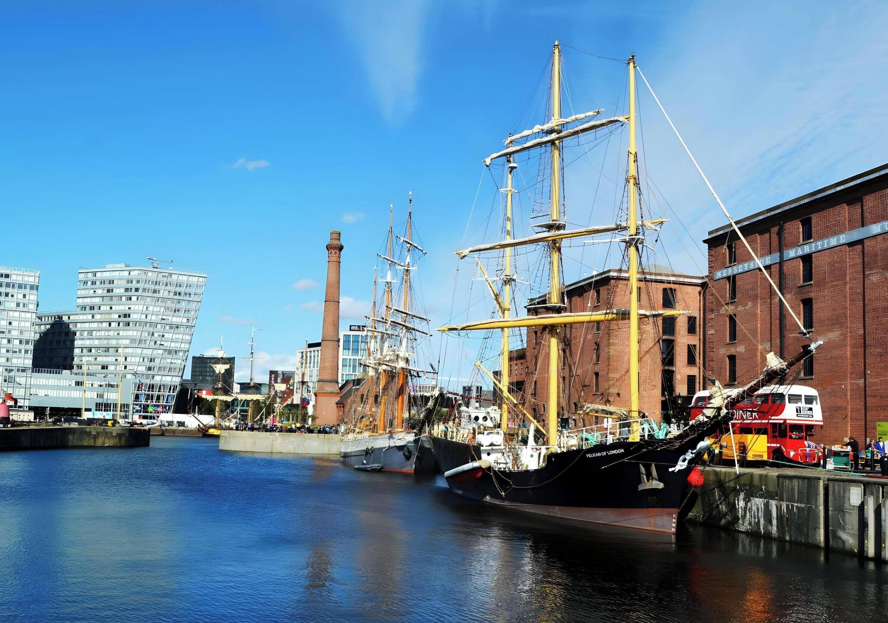 A harbor with tall ships docked, a brick building labeled 'MARITIME,' and modern buildings in the background.