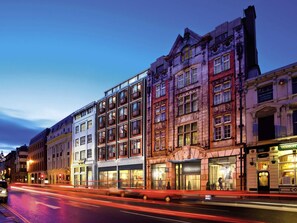 A multi-story building with a mix of architectural styles, including a prominent corner building with a sign for 'Pioneer Buildings'.