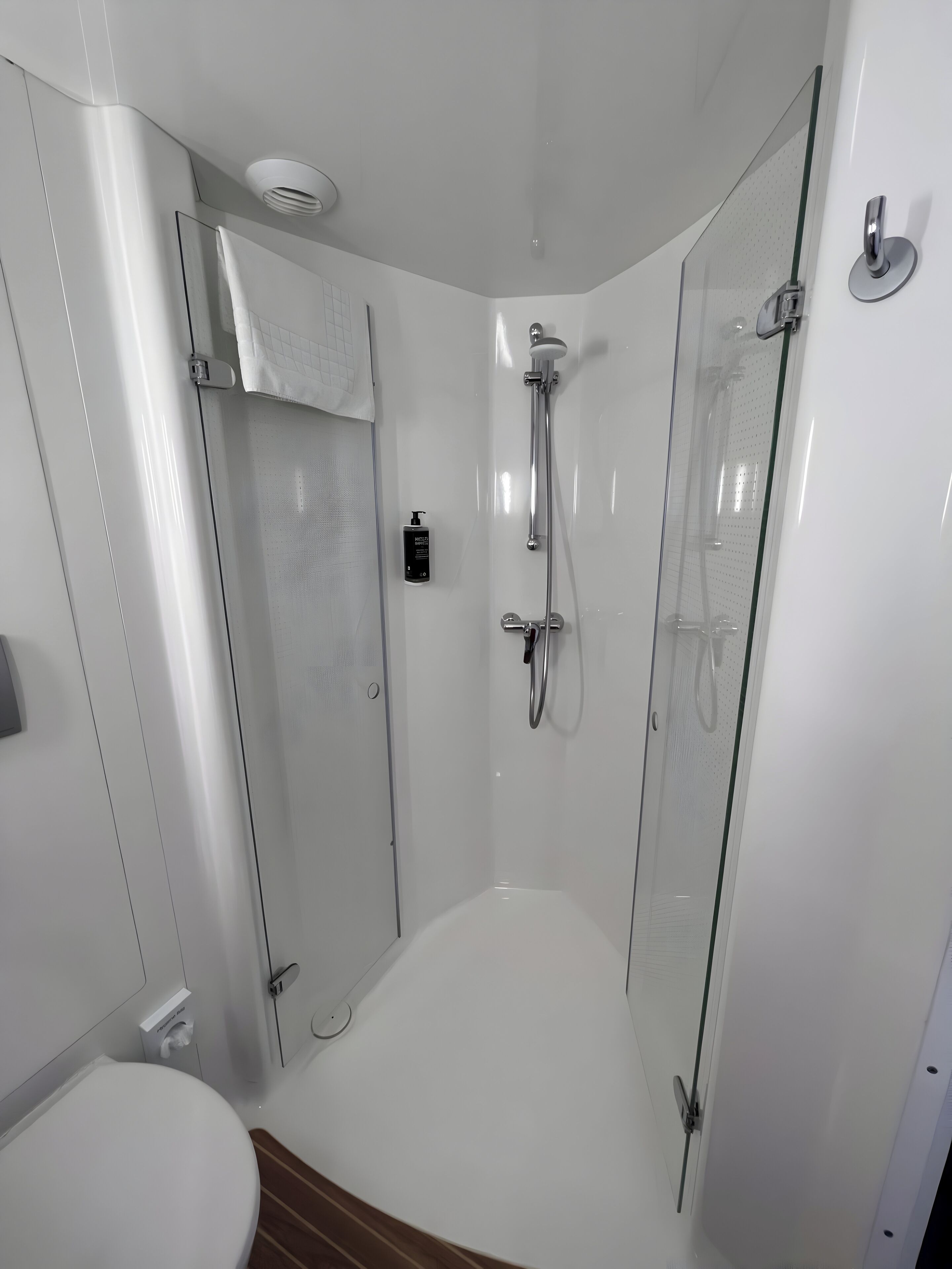 Ein modernes Badezimmer mit einer Duschkabine, einer Toilette und einem Handtuchhalter.