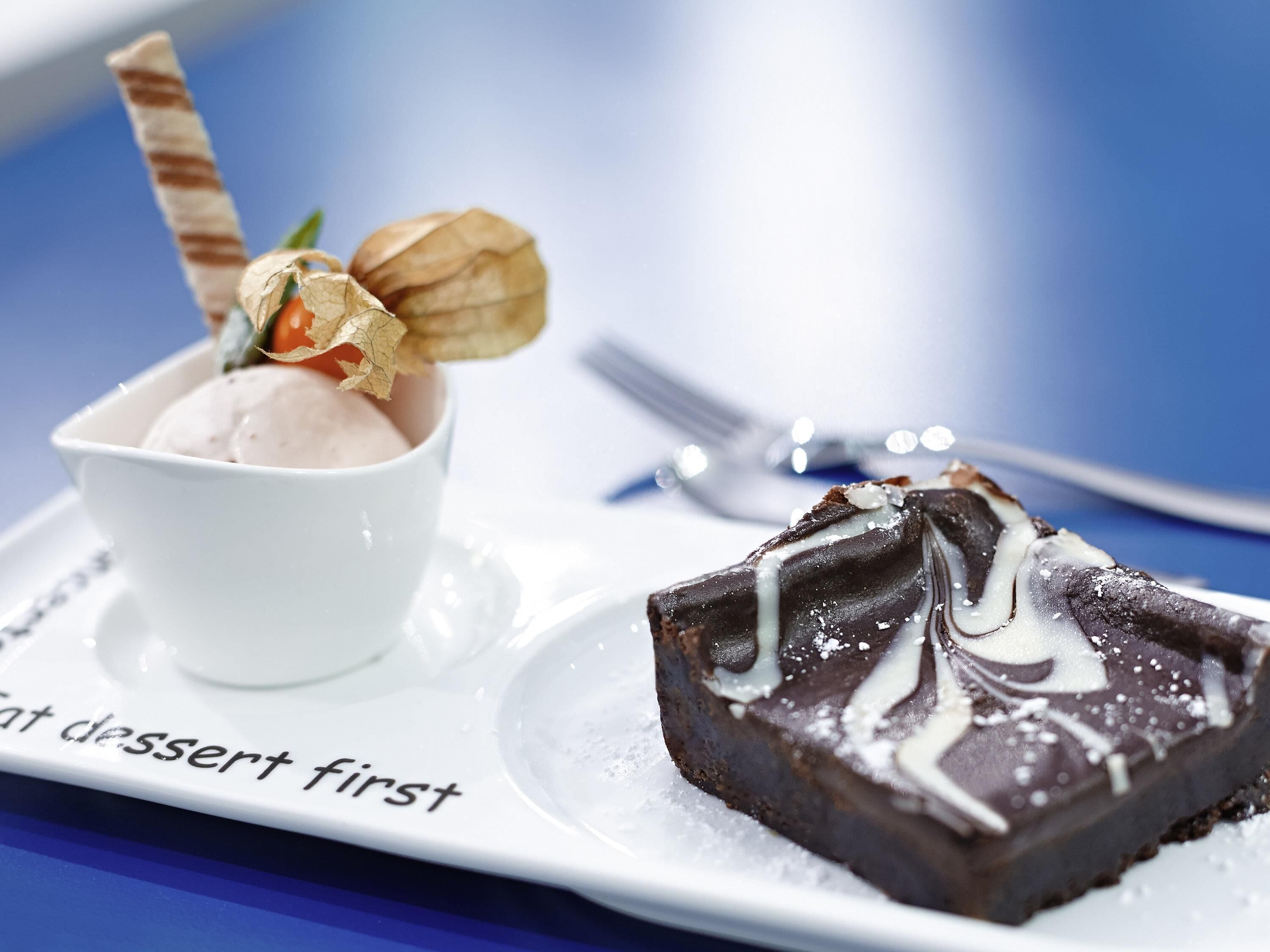 Un plato de postre con una tarta de chocolate y una bola de helado.