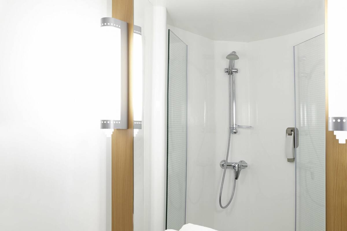 A modern bathroom with a shower, a toilet, and a sink.