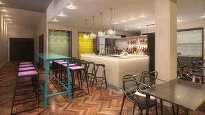 A modern bar area with a central island, bar stools, and a herringbone wood floor. - ibis Styles Liverpool Centre Dale Street (Liverpool)