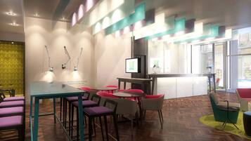 A modern interior with a wooden herringbone floor, teal and purple chairs, and a central table with a TV.