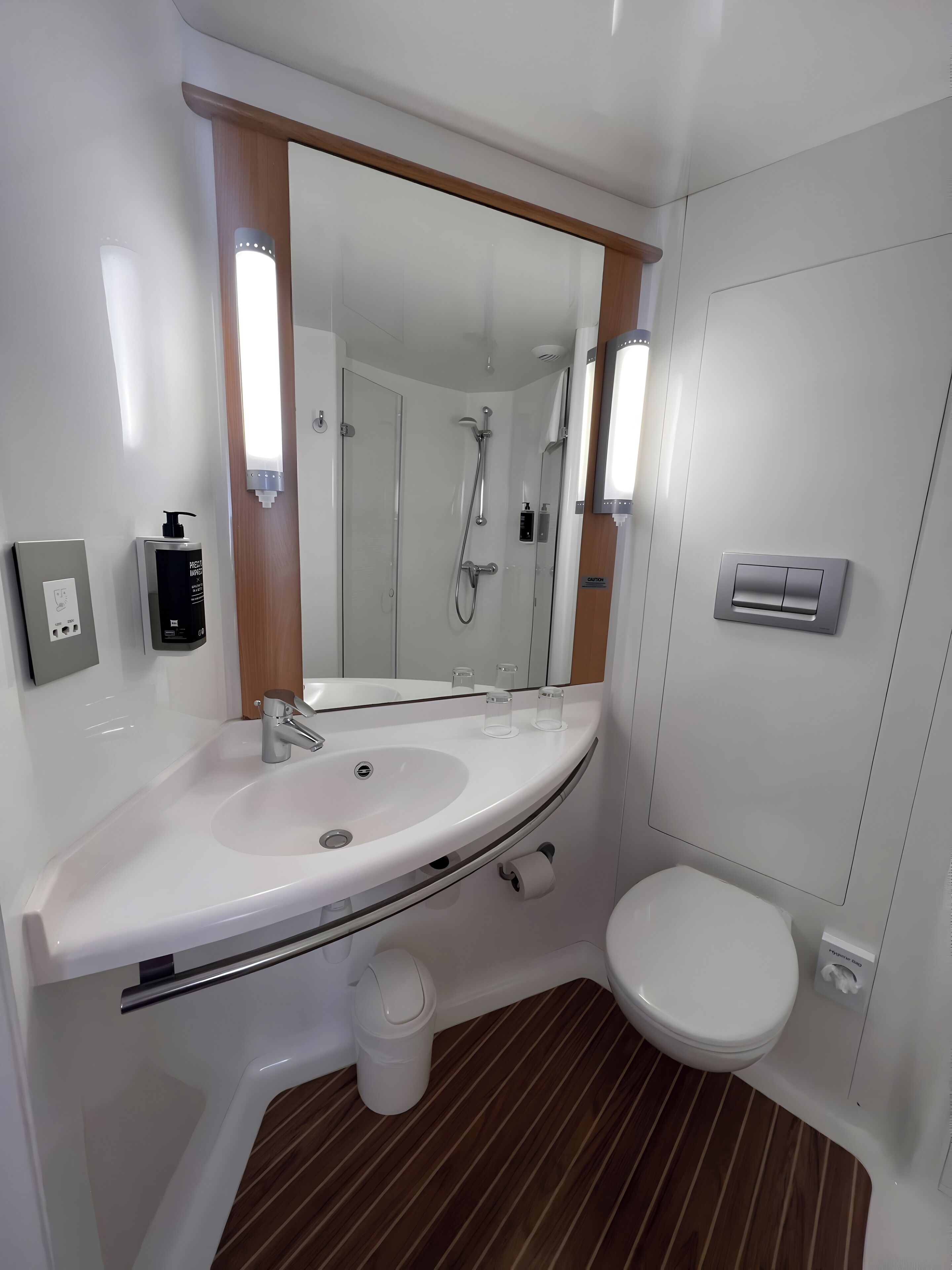 Ein modernes Badezimmer mit Waschbecken, Spiegel und Toilette in Weiß.
