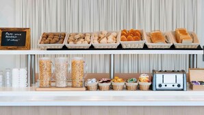 Un bufé de desayuno con diversas opciones de comida y un tostador.